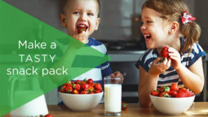 Two kids eating strawberries with text reading: Make a tasty snack pack