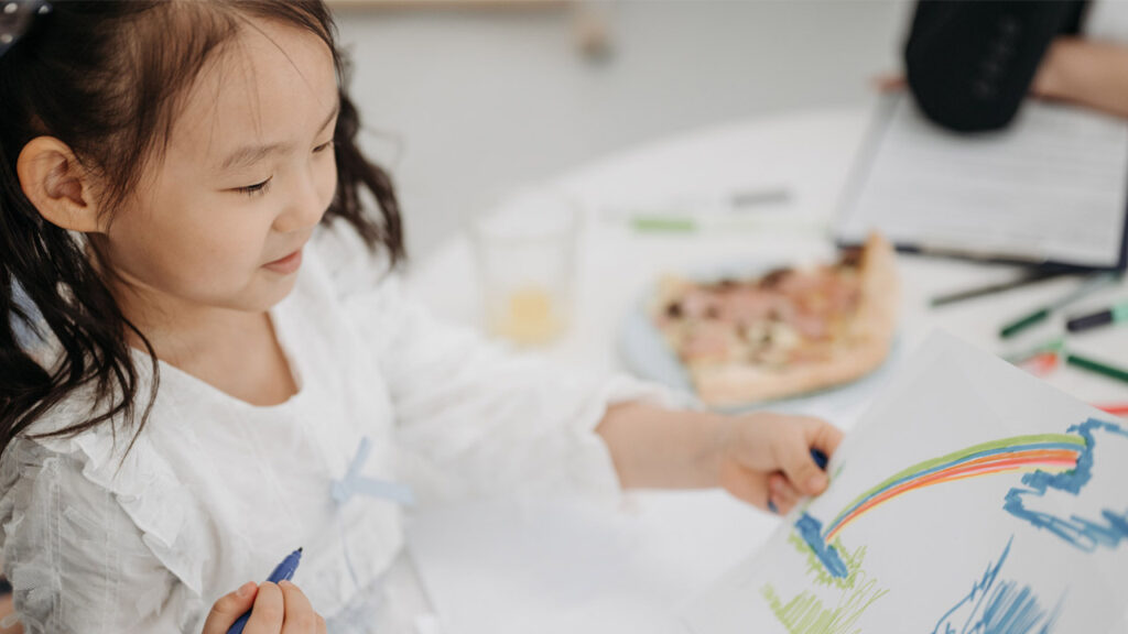 A girl shares a coloring page with her parent